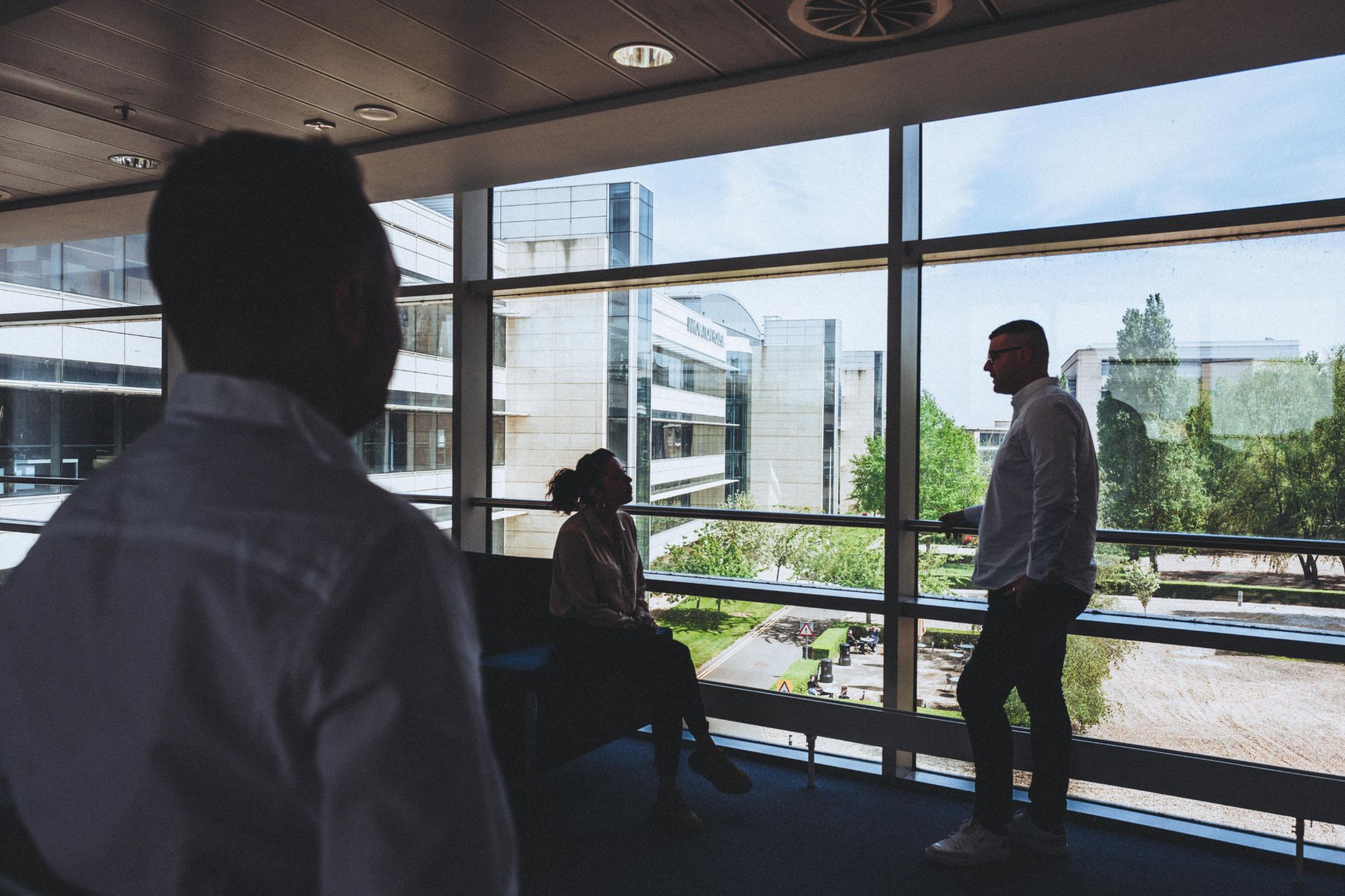 The Wave Search team talking by the windows overlooking Discovery Park