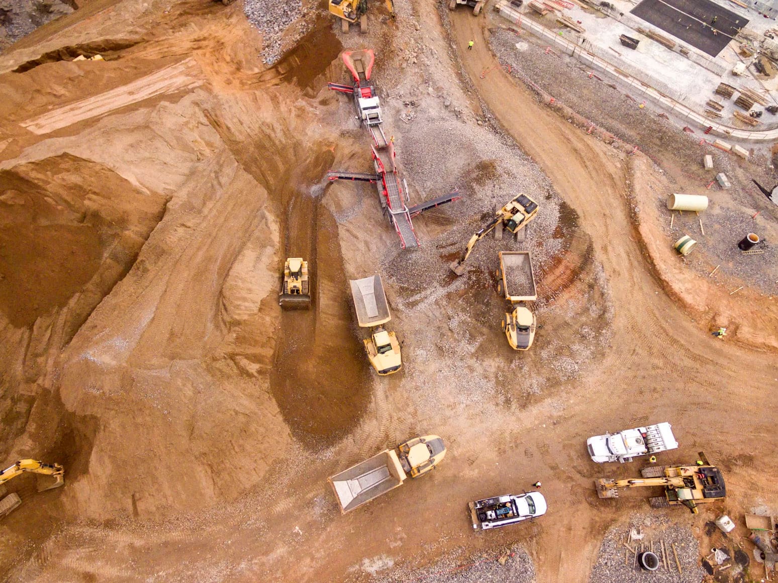 Aerial view of trucks and machinery working an open mine site
